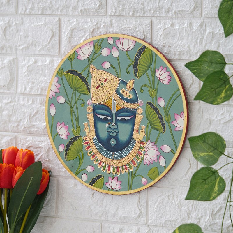 This beautiful pichwai painting depicts Shrinathji, a revered Hindu deity, adorned with flowers and jewels