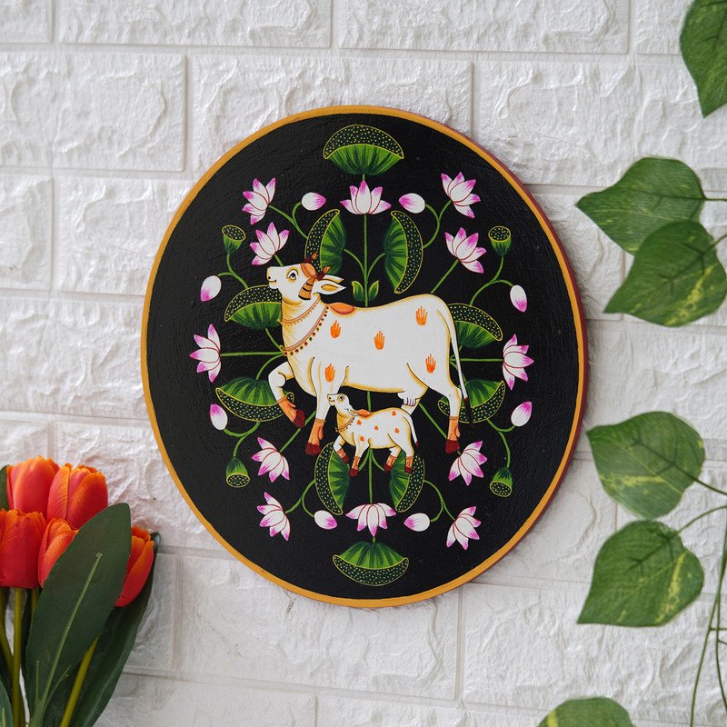 This beautiful pichwai painting features a mother cow and her calf nuzzling each other, surrounded by a vibrant array of flowers.