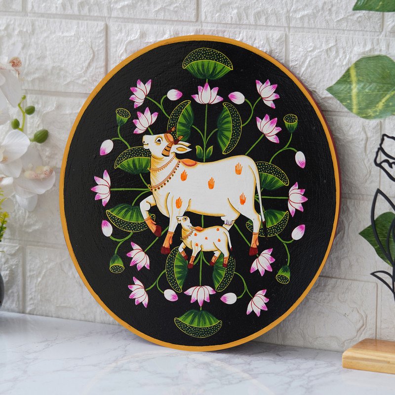 This beautiful pichwai painting features a mother cow and her calf nuzzling each other, surrounded by a vibrant array of flowers.