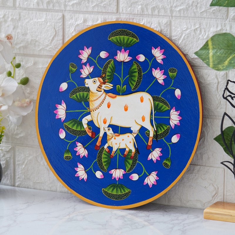 This beautiful pichwai painting features a mother cow and her calf nuzzling each other, surrounded by a vibrant array of flowers.