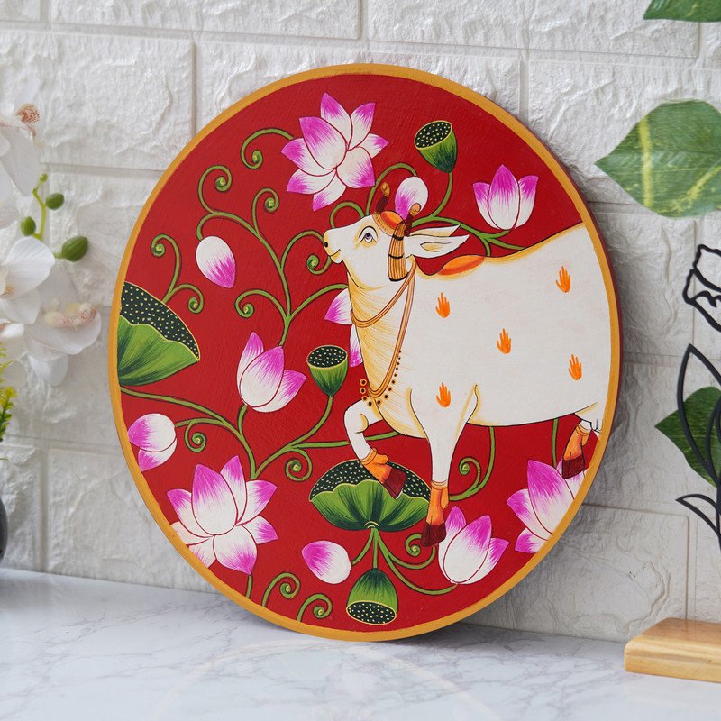 This beautiful pichwai painting features a serene white cow adorned with a vibrant floral headdress.