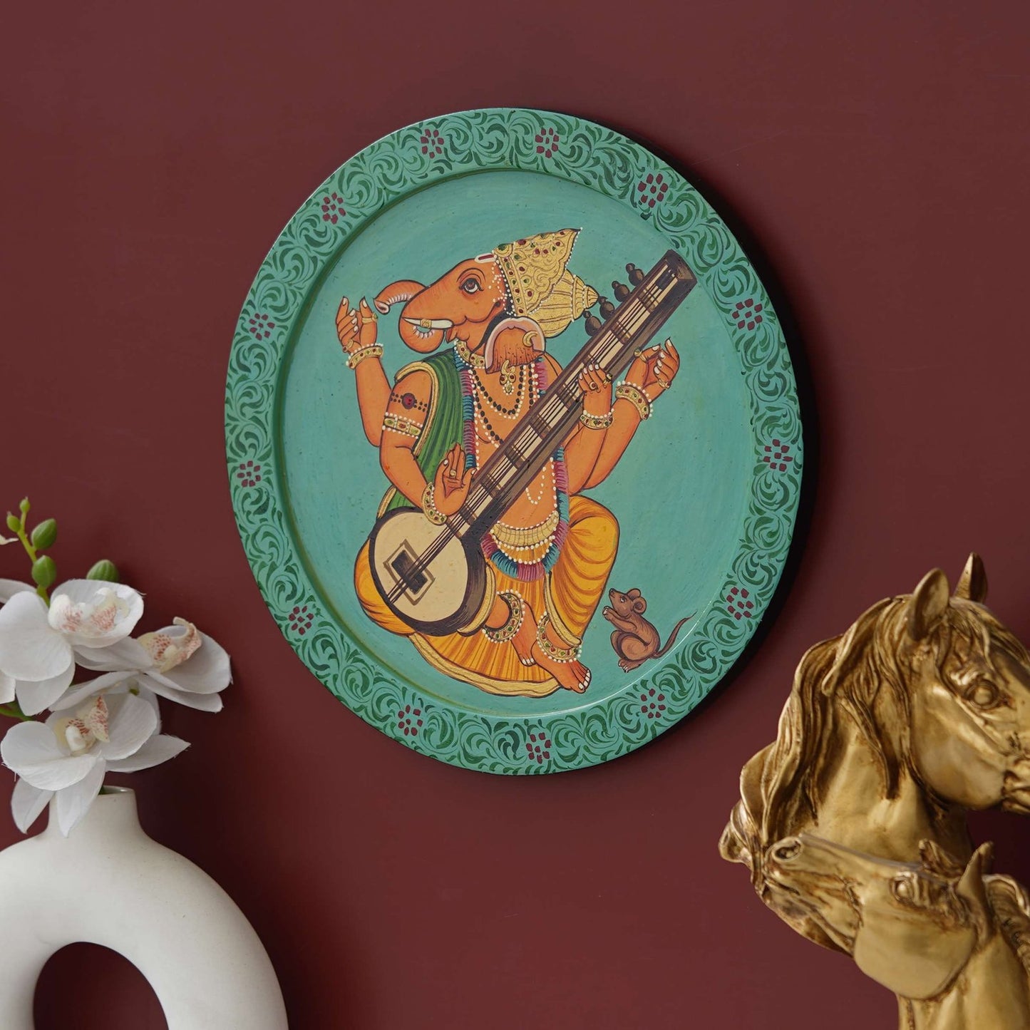 This beautiful pichwai painting features a majestic ganesh ji perched on a vibrant flowering branch.