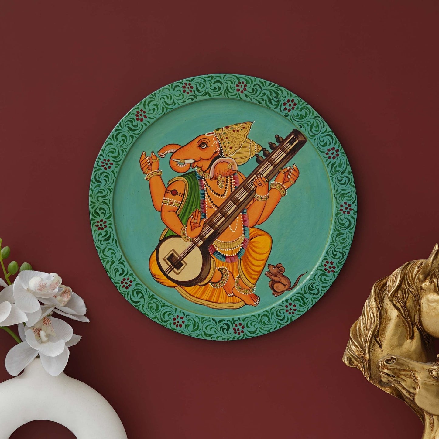 This beautiful pichwai painting features a majestic ganesh ji perched on a vibrant flowering branch.