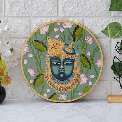 This beautiful pichwai painting depicts Shrinathji, a revered Hindu deity, adorned with flowers and jewels