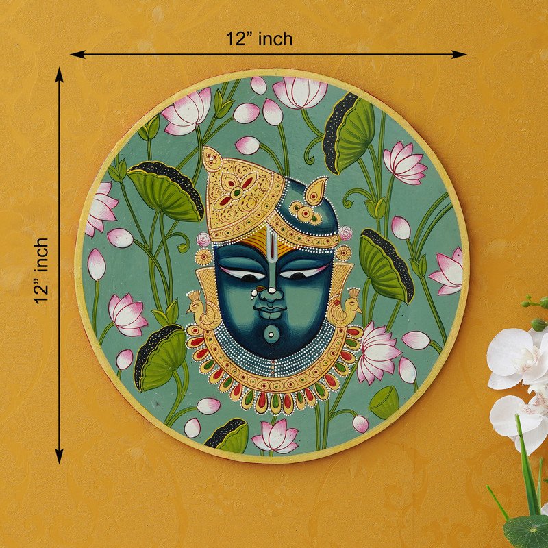 This beautiful pichwai painting depicts Shrinathji, a revered Hindu deity, adorned with flowers and jewels